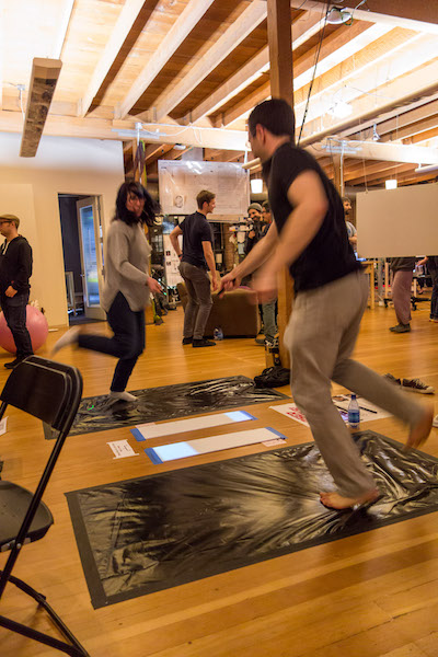 Two people mid-jump during a round of Laser Socks